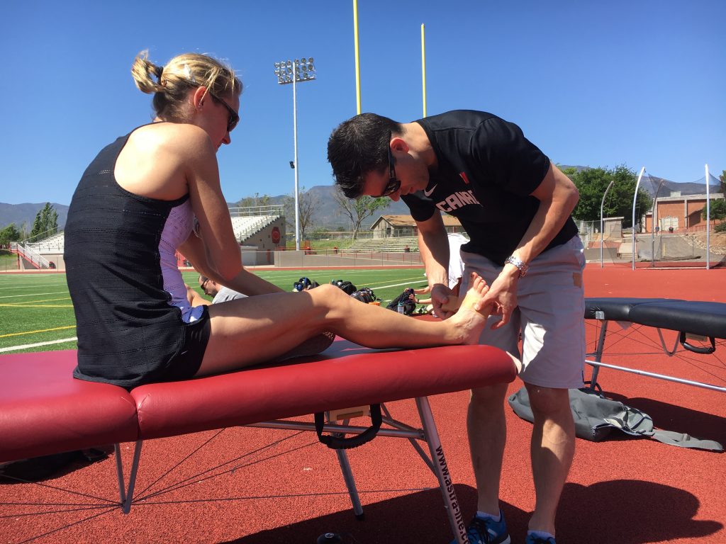 Sports Physio assessing athlete on bench