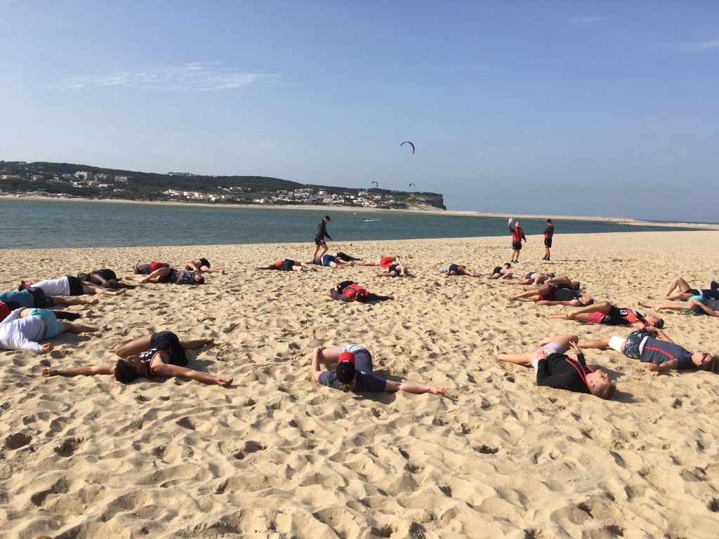 Sports Physiotherapist leading beach stretching clinic