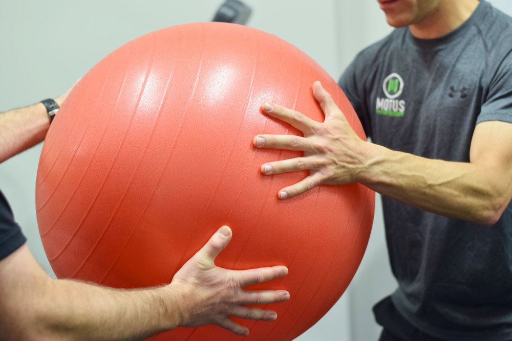 Sport physio with athlete and ball